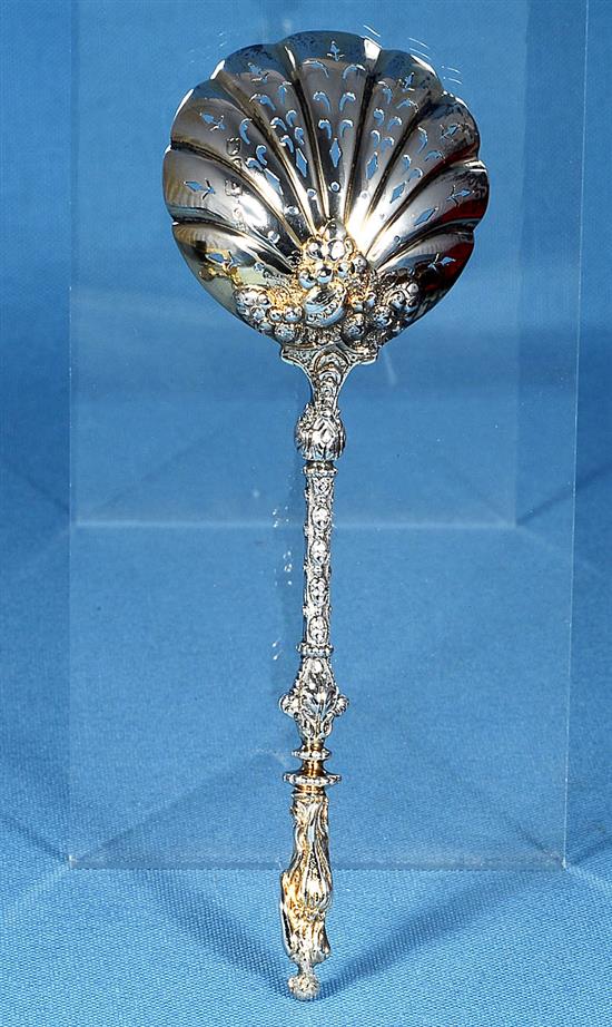 A cased set of four Victorian silver parcel gilt fruit serving spoons and a sugar sifter, spoon 197mm, weight 12.4oz/388 grms.